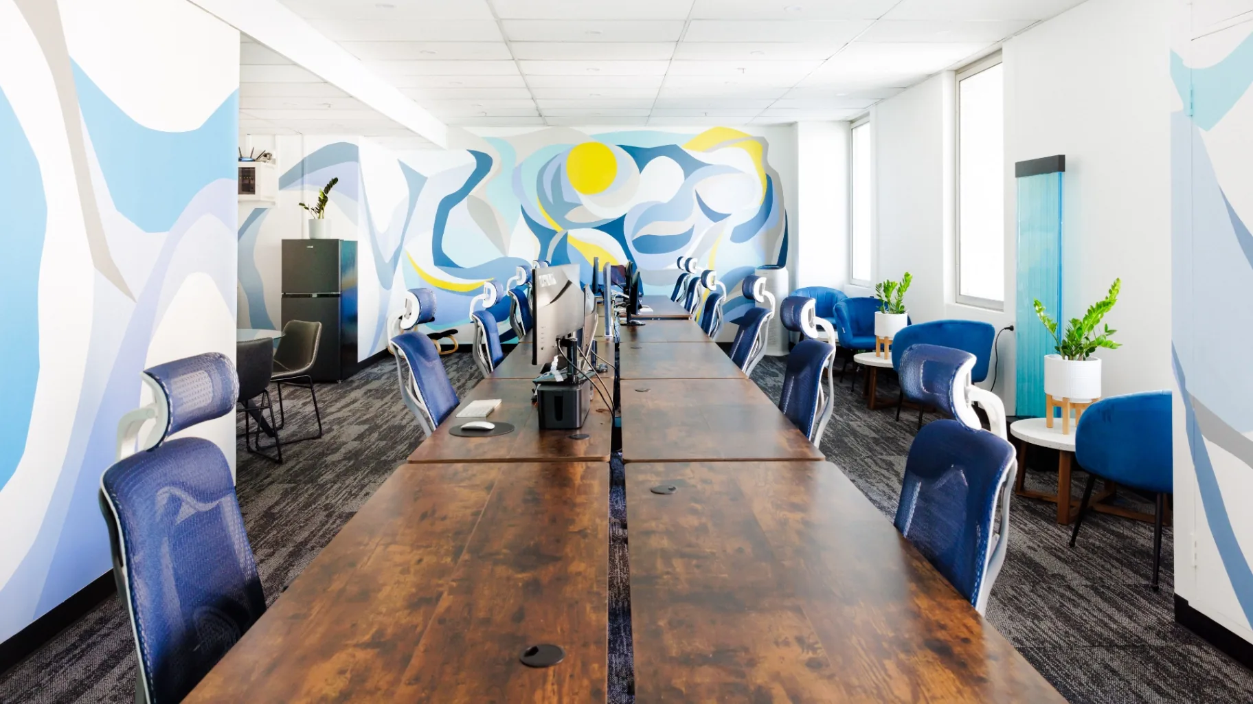 The long shared worktable at King Work, beneath the mural