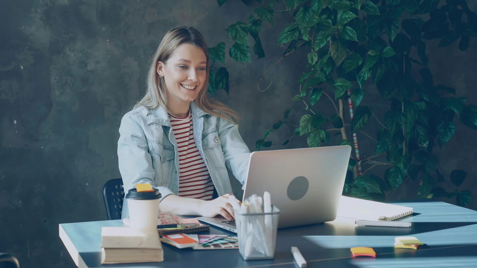 Happy entrepreneur working on a laptop in a home-office workspace